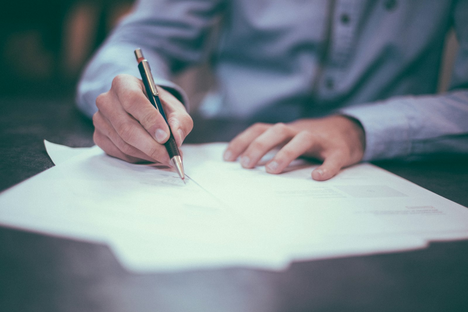 Hands signing mediation paperwork
